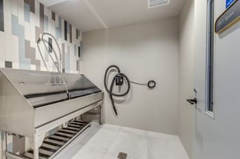 A clean, modern kitchen with a stainless steel sink and a white tile backsplash.